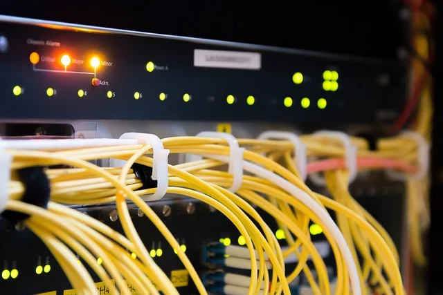 Server rack with yellow fiber optic cables and glowing lights