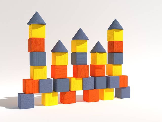 Colorful wooden toy blocks stacked into towers on a white background