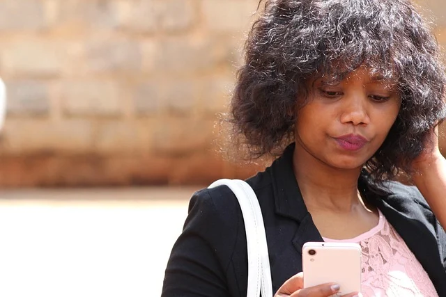 A woman looking at her phone, possibly streaming content.