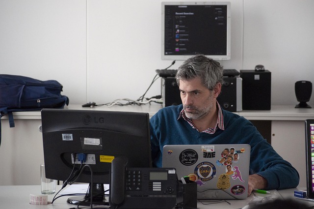 A man sitting at a desk working on a computer