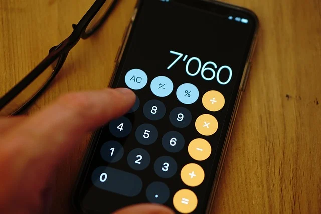 A hand using a calculator app on a smartphone, showing a number.
