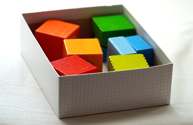 Colorful wooden building blocks inside a white box
