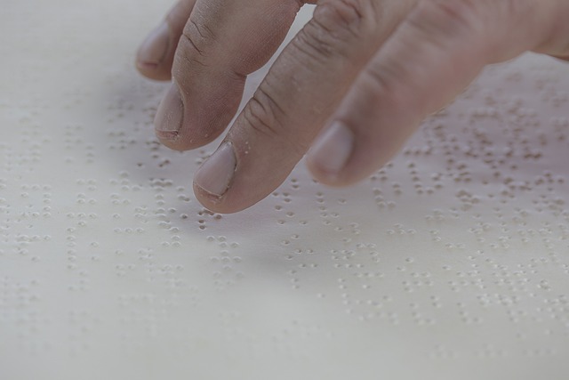 Fingers reading Braille text on paper