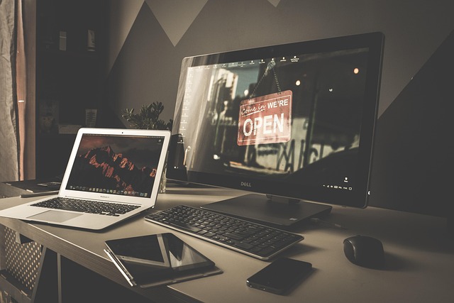A computer workspace setup with laptop, monitor, tablet, and smartphone