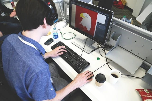 A person using a computer with an image editing software open, showing an eagle design.