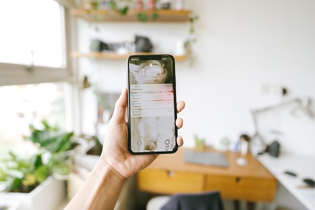 Hand holding a smartphone displaying notifications on its lock screen