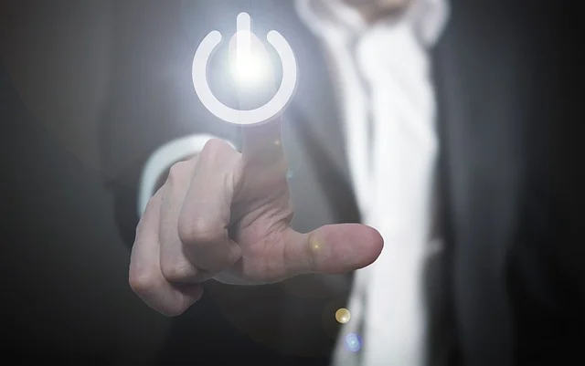 A finger pressing a glowing power button, symbolizing a launch or start.