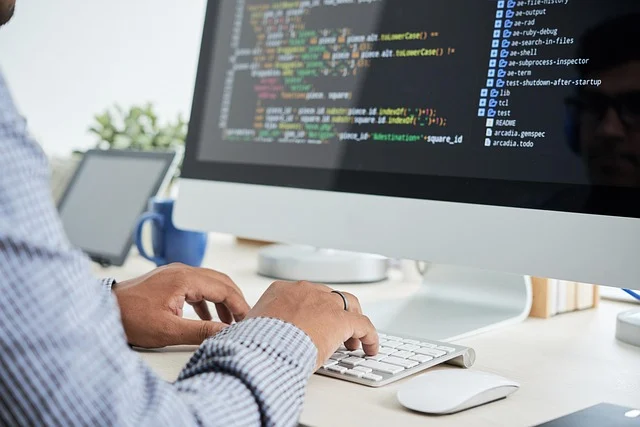 A person coding on a computer, showing software development.