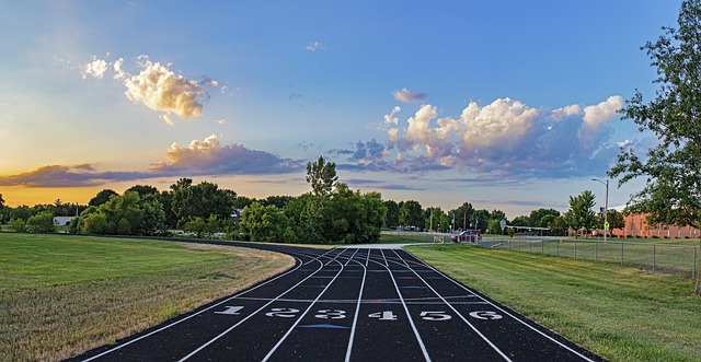 A running track with numbered lanes under a cloudy sky