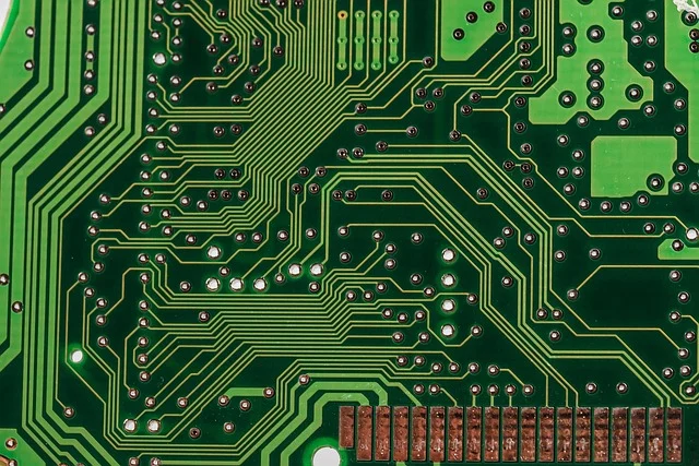 A close-up view of a green printed circuit board with traces
