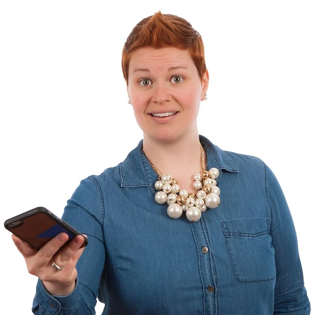 A woman holding a phone with a surprised expression.