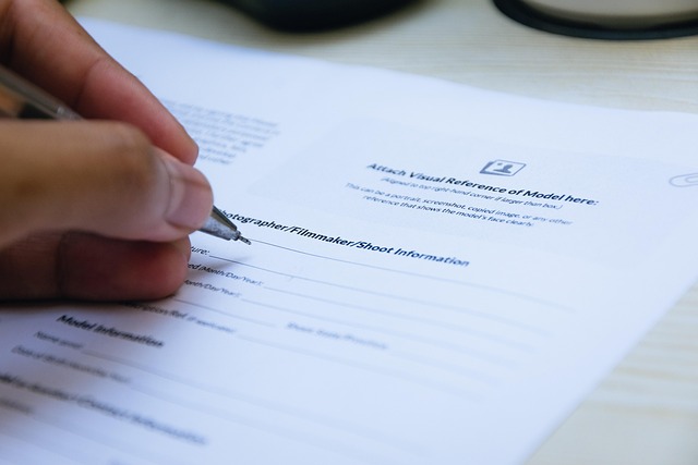 A hand using a pen to sign a document or form