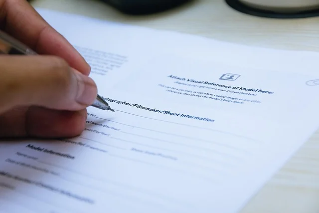 A hand using a pen to sign a document or form