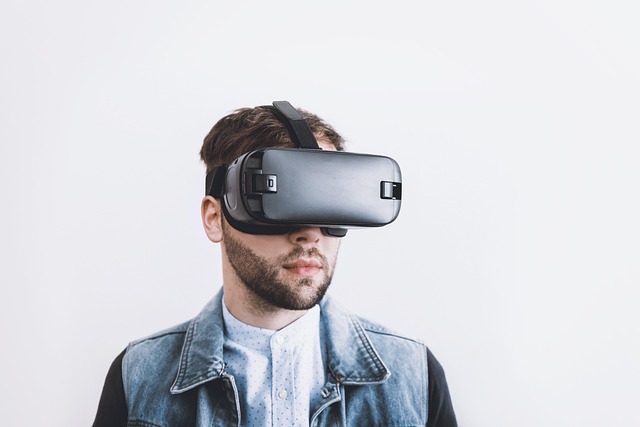 A man wearing a virtual reality headset against a plain background