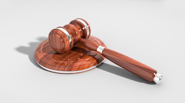 A wooden judge's gavel resting on a sounding block