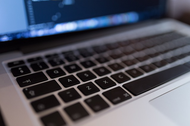 Close up of a laptop keyboard with code on screen
