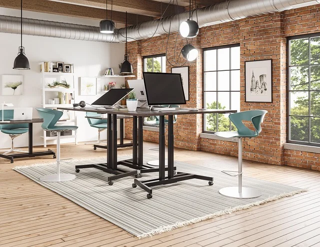 A modern office space with multiple remote work setups, including standing desks.