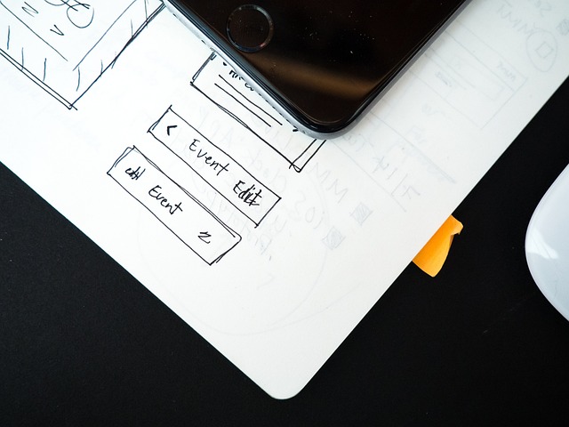 A smartphone on top of hand-drawn mobile app UI sketches