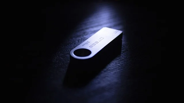 A metallic USB flash drive on a dark background