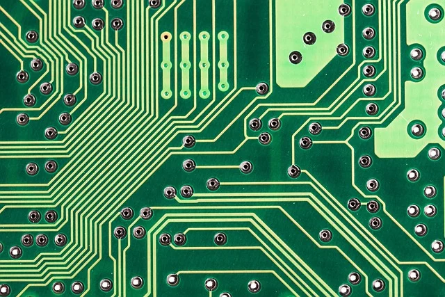 A close-up of a green circuit board with traces and solder points.