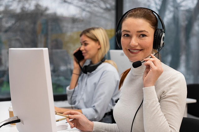 A customer support representative wearing a headset working at a computer