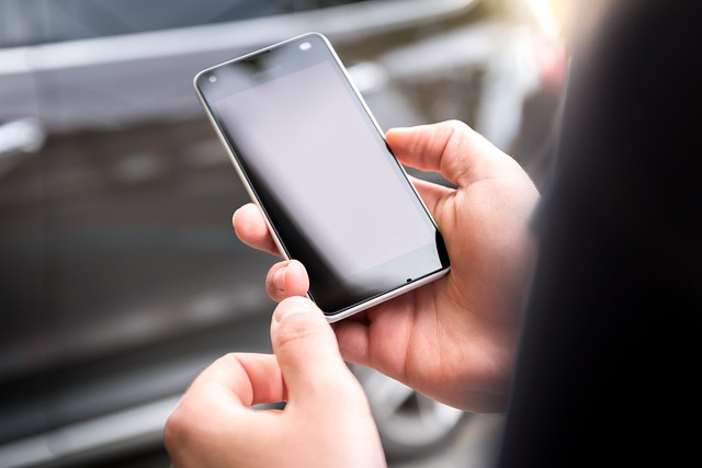 Hands holding a smartphone with a blank screen