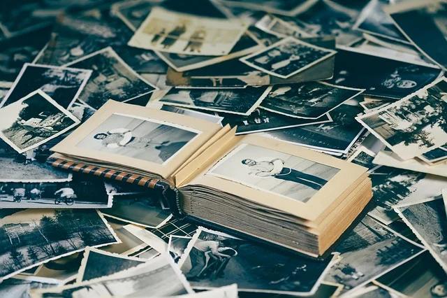 A collection of old black and white photos and a photo album.