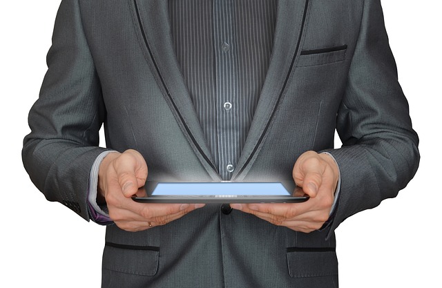 A businessman in a suit holding a glowing tablet computer