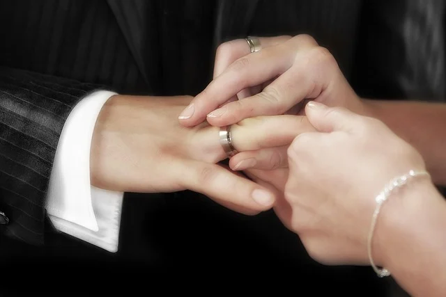 Matrimony Mobile App Development Cost Estimation With Key Features: A woman putting a wedding ring on a man's finger.