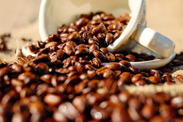 Coffee beans spilled from a cup, suggesting a liquid spill.