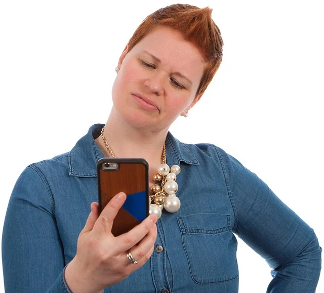 A woman looking confused at her phone.