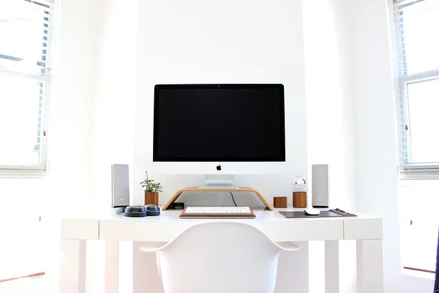 A clean, minimalist desk setup with a computer, keyboard, and mouse.