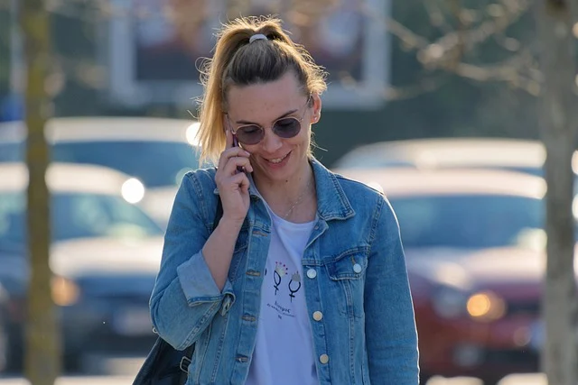 A woman wearing sunglasses talking on a smartphone outdoors