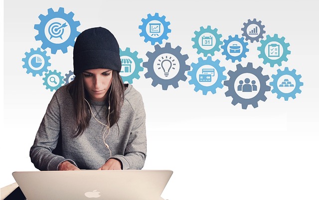 A person working on a laptop with gear icons in the background
