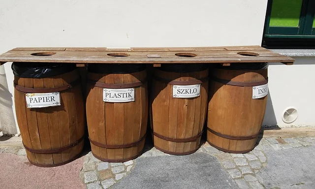 Four wooden barrels for waste sorting, labeled in Polish.