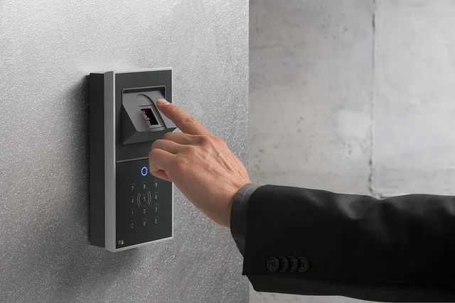 A person scanning their finger on a biometric access control panel