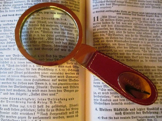 A magnifying glass over an open book with printed text