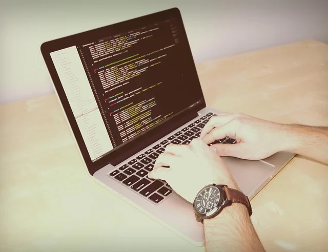 A person typing code on a laptop, demonstrating practical experience.