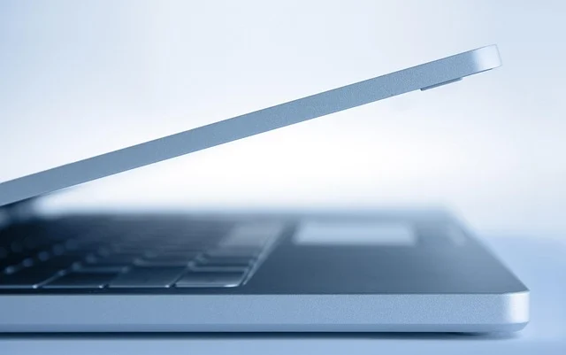 A partially open laptop from a side profile view