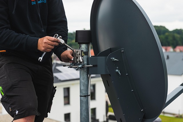Technician installing a satellite dish on a roof