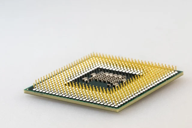 The underside of a computer CPU processor chip with gold pins