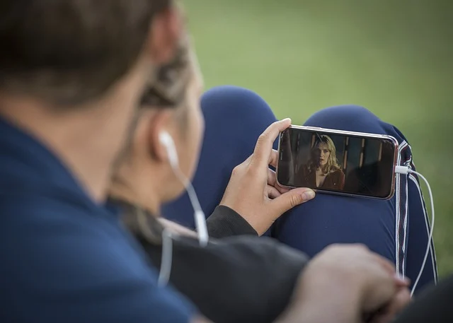 A person watching a video on a smartphone with earphones