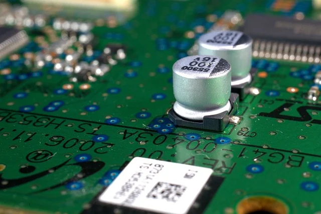 What is a logic gate: Close-up of capacitors on a green printed circuit board