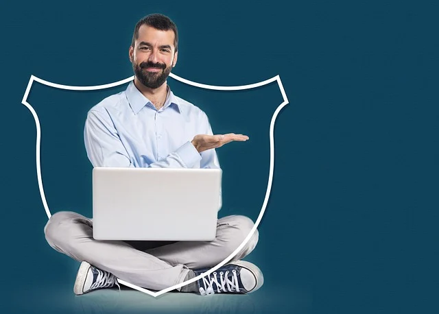 A man with a laptop sitting inside a security shield outline