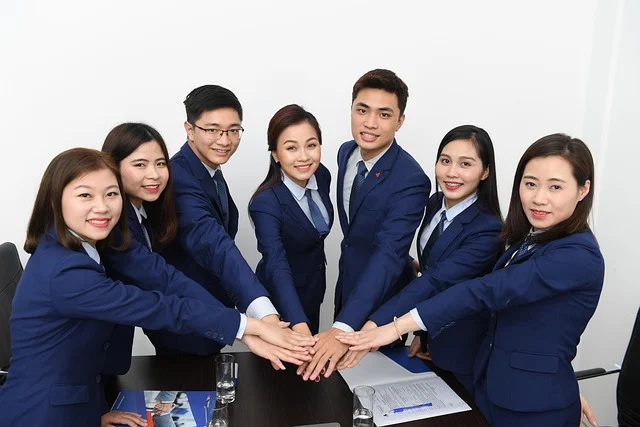 A group of business people with hands stacked together, symbolizing teamwork.