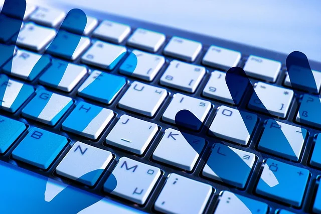 A computer keyboard with blue digital hand silhouettes
